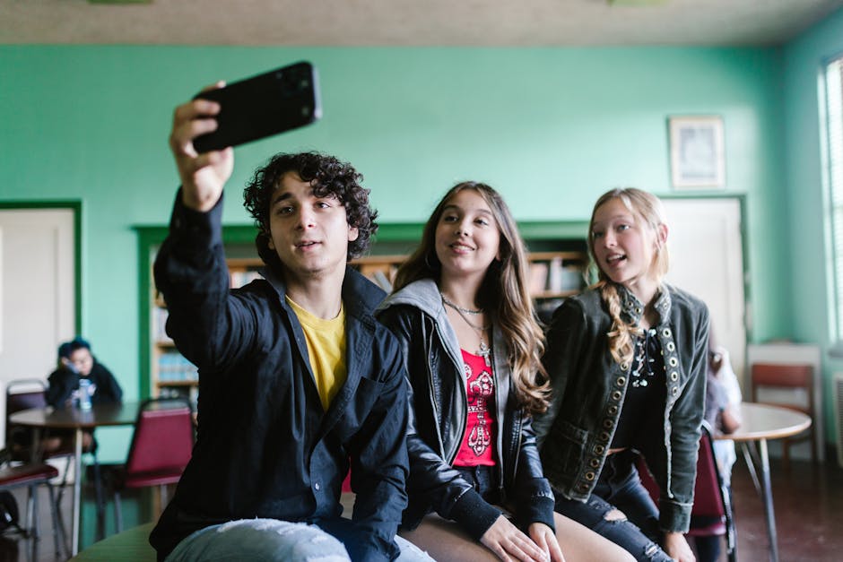 Défi photo en équipe Group of teenagers capturing a fun selfie together indoors, showcasing friendship.