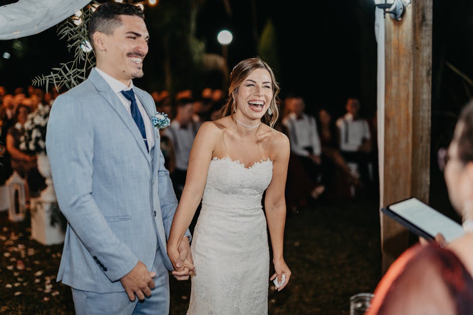 Bride and groom laughing and holding hands during a nighttime outdoor wedding ceremony. Livre d'or vidéo