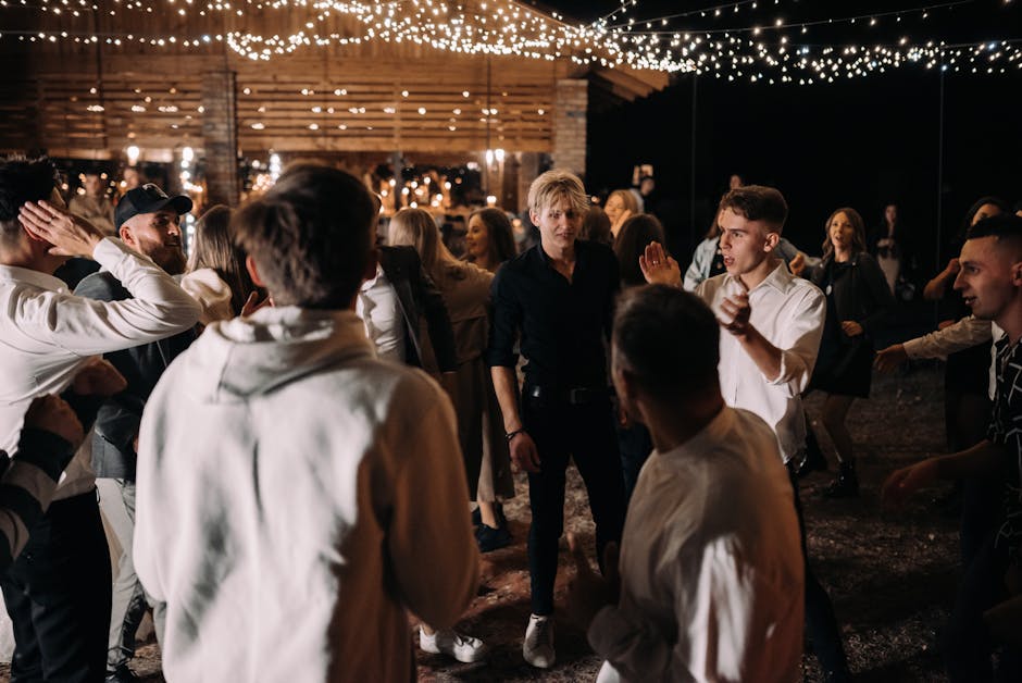 Guests enjoy an energetic night of dancing under string lights at an outdoor wedding.