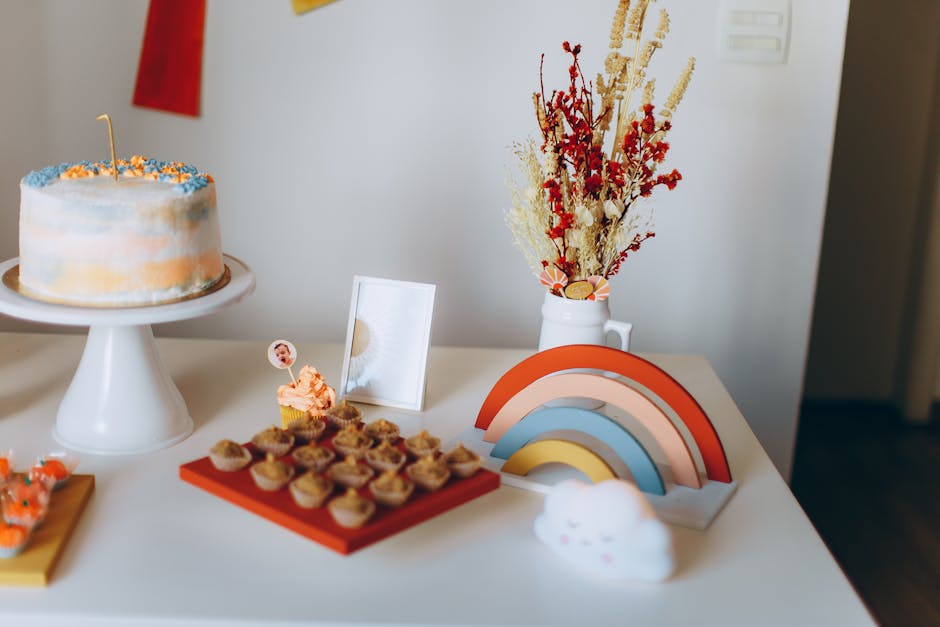 Vibrant dessert table with a cake, cupcakes, and decorations perfect for a celebration.