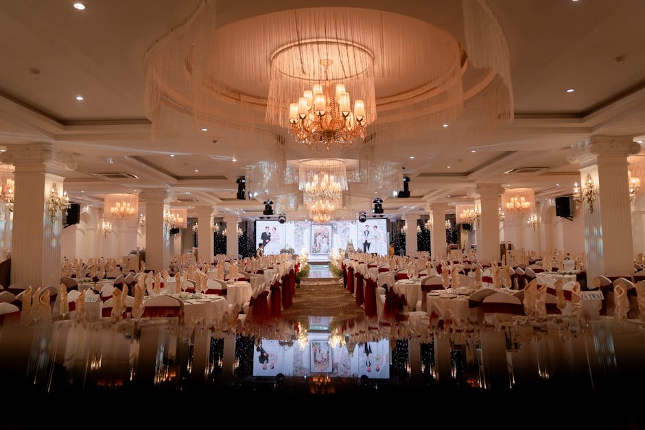 Luxurious ballroom beautifully arranged for a grand evening event, with chandeliers illuminating the decor.