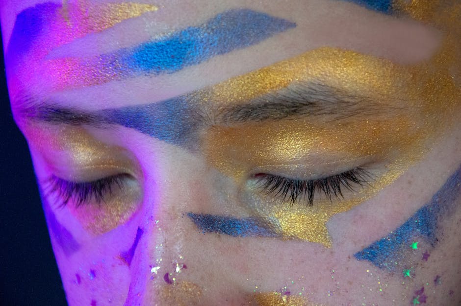 Closeup of artistic festival makeup with vibrant colors on closed eyes.