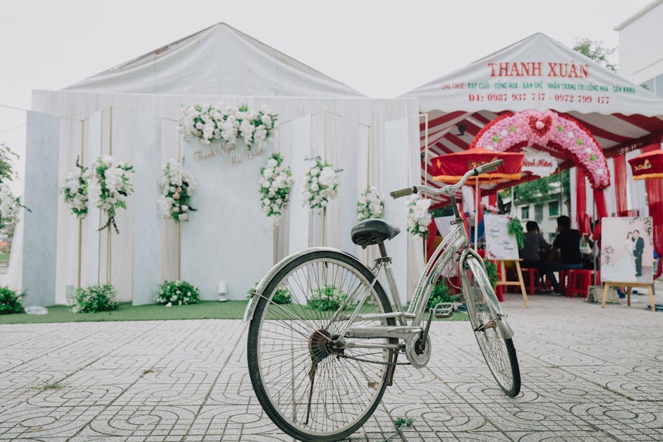 A bicycle parked outside a colorful wedding venue adorned with floral decorations, capturing a festive outdoor celebration. photobooth en exterieur 